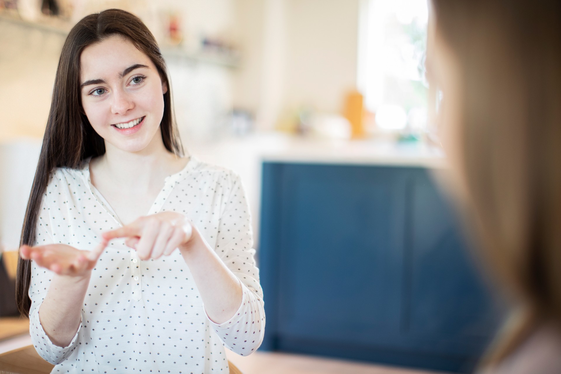 Two Teenage Girls Having Conversation Using Sign Language